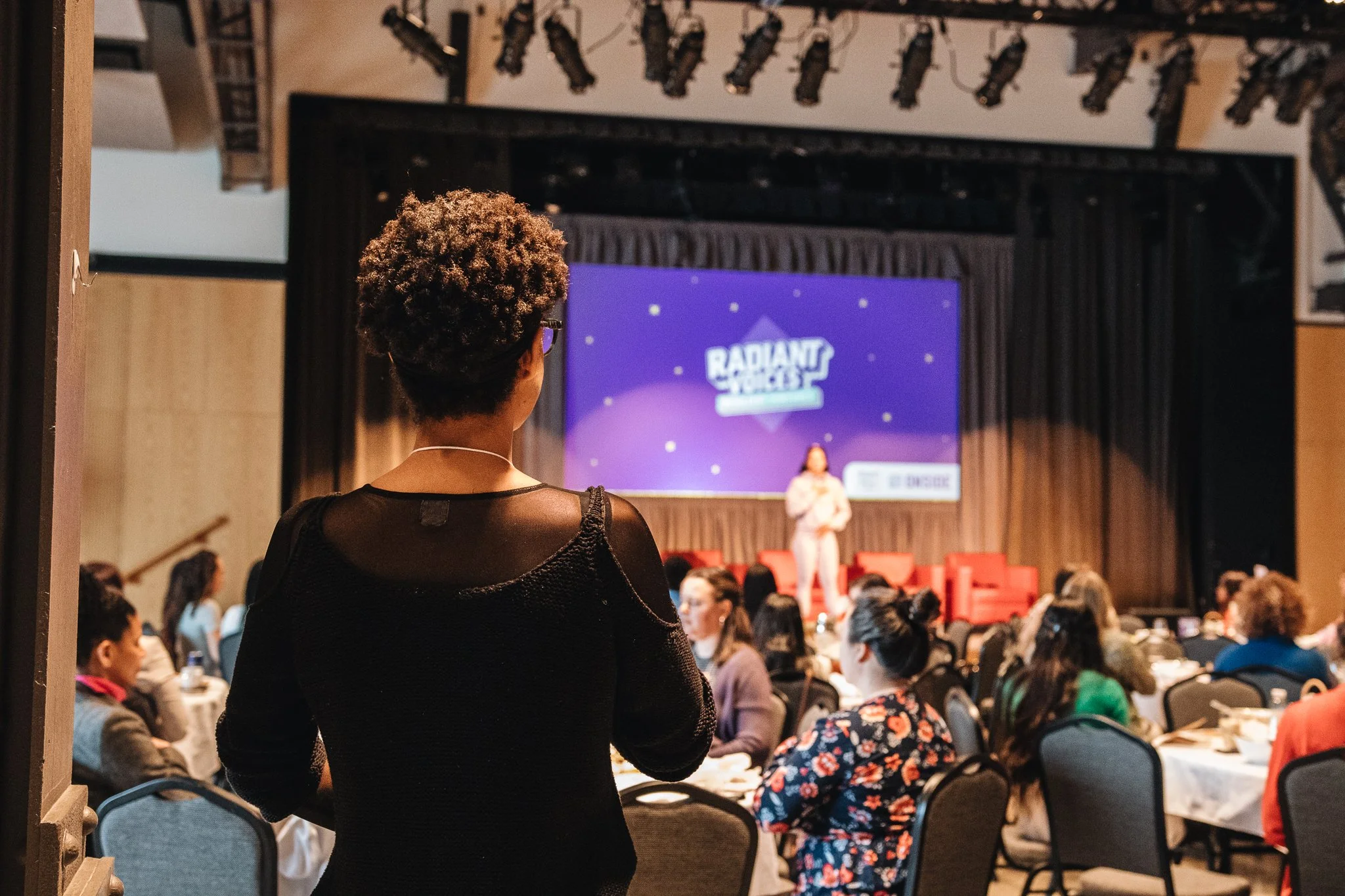 An attendee watches a speaker at an ONSIDE Radiant Voices gathering