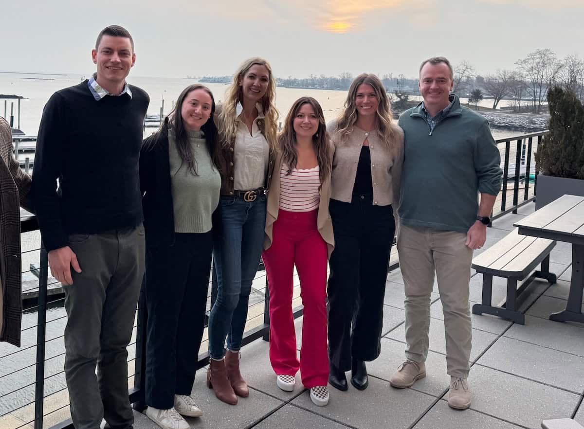 Onward team members standing together on a patio overlooking the water
