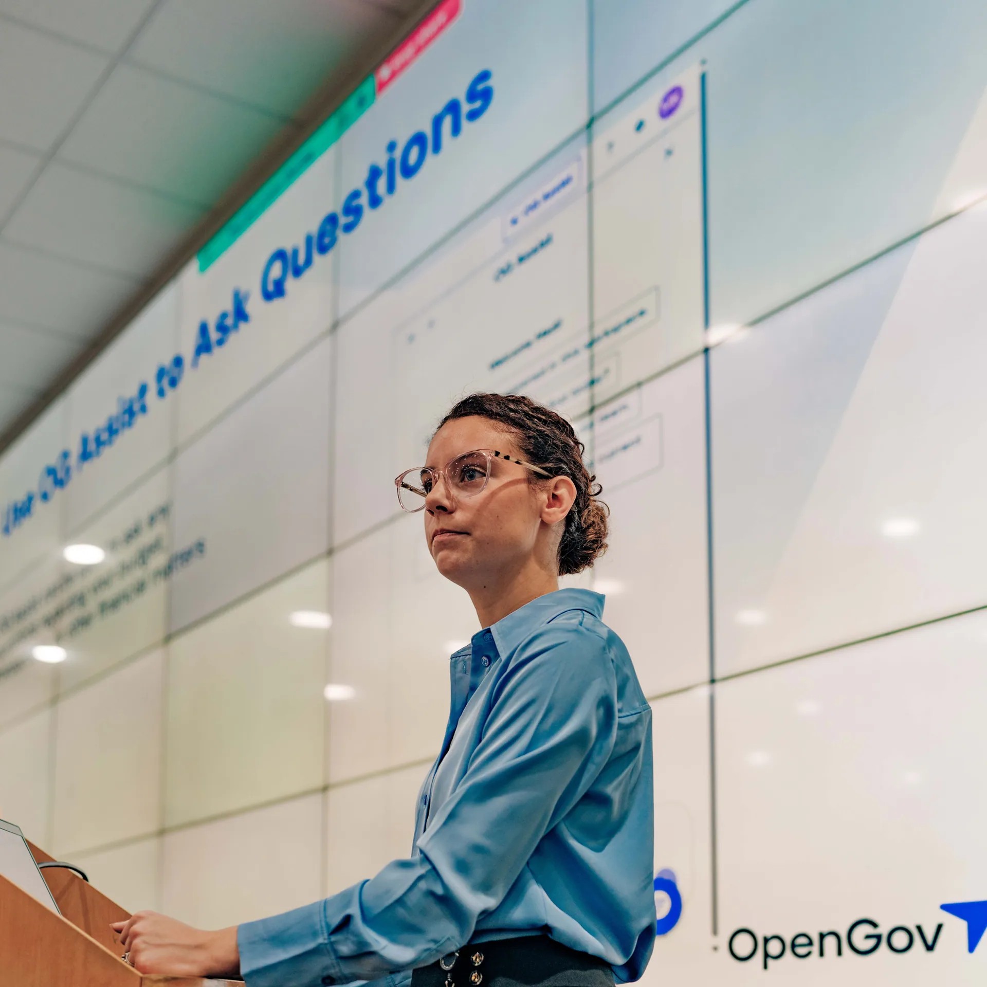 A public servant presenting in front of an OpenGov display
