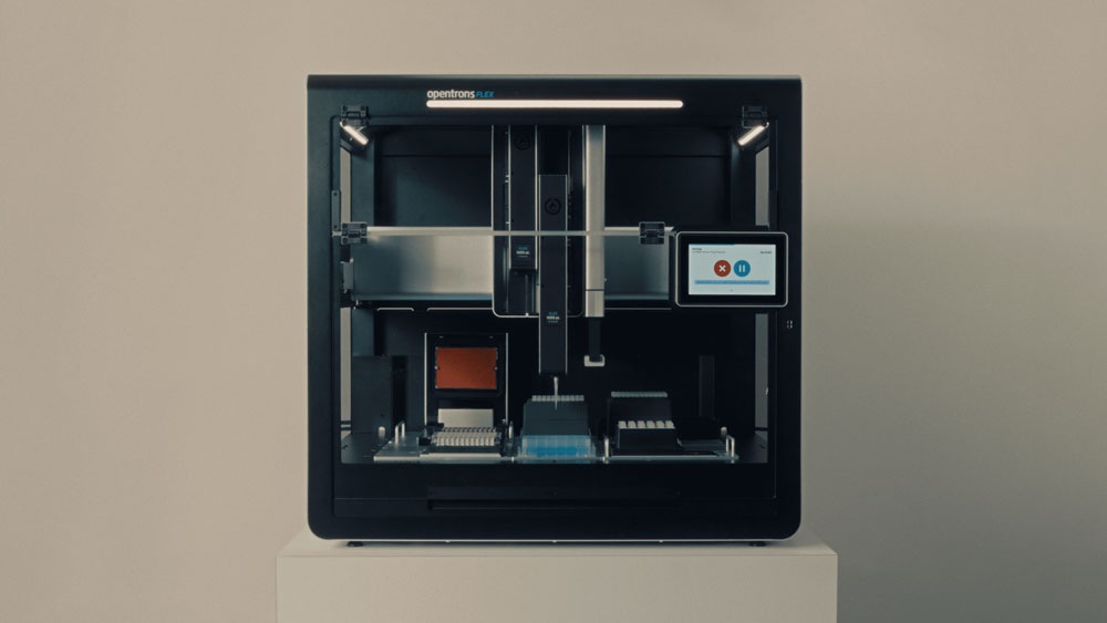 An Opentrons Flex liquid-handling robot with pipettes, deck labware and a touchscreen