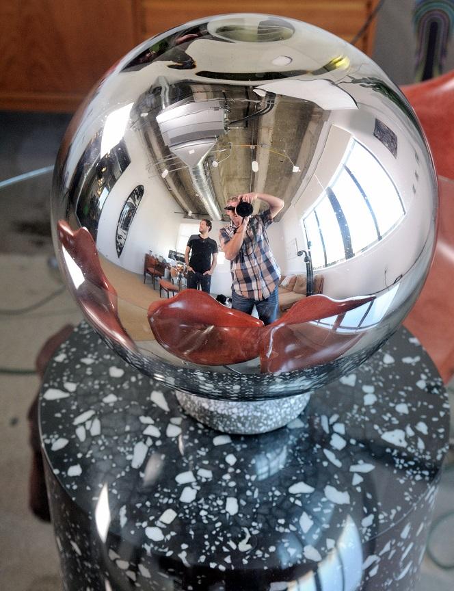 Ophir Tanz and photographer Thomas Wasper reflected in a polished sculptural object in the GumGum office
