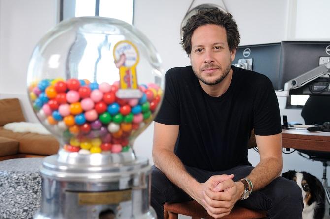 Ophir Tanz seated in GumGum’s office beside a vintage gumball machine