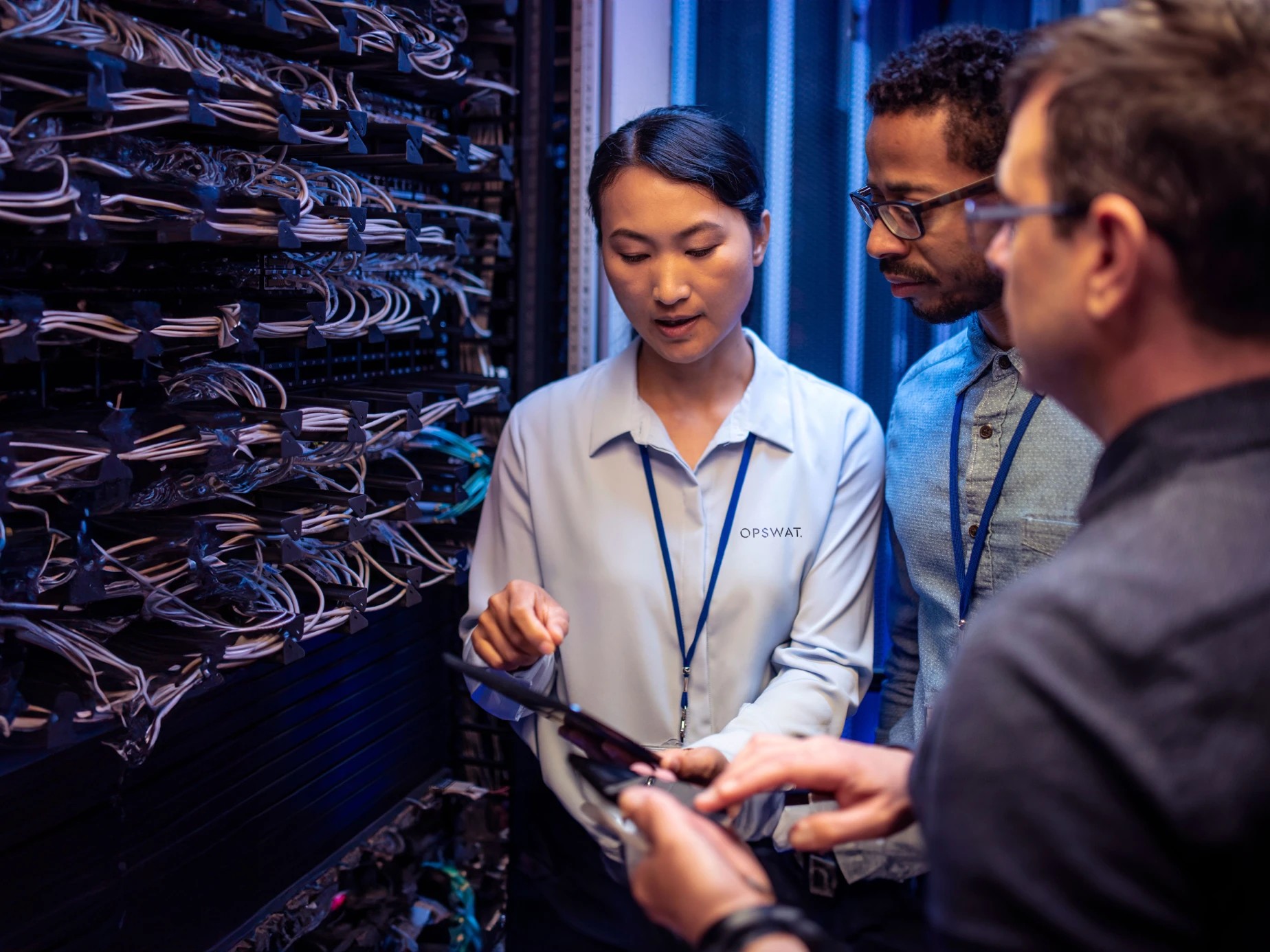 OPSWAT team reviewing a tablet in a server room