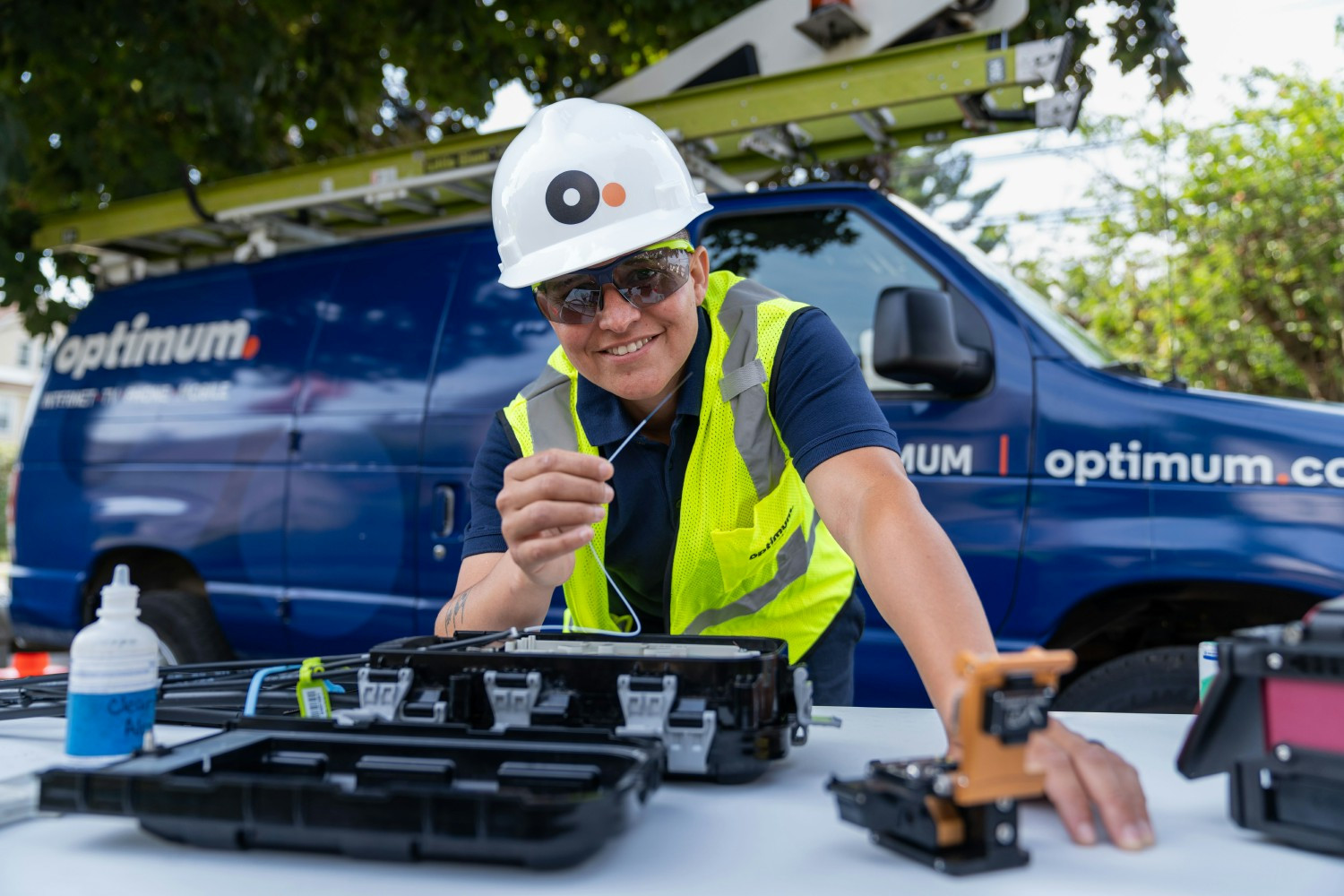 An Optimum field technician handles fiber beside a service van in Connecticut.