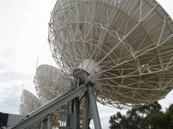 Large white satellite dishes and their supporting steelwork at Optus’s Belrose earth station