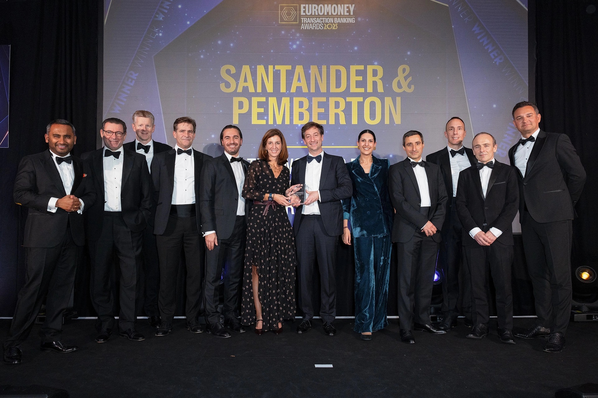 Oren Bass holding an award beside Mencía Bobo, surrounded by colleagues from Invensa, Santander and Pemberton
