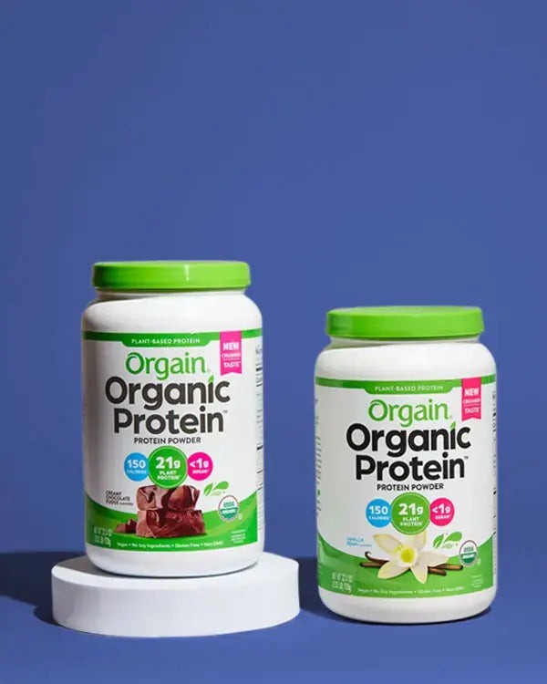 Chocolate and vanilla tubs of Orgain organic plant protein powder on a blue background