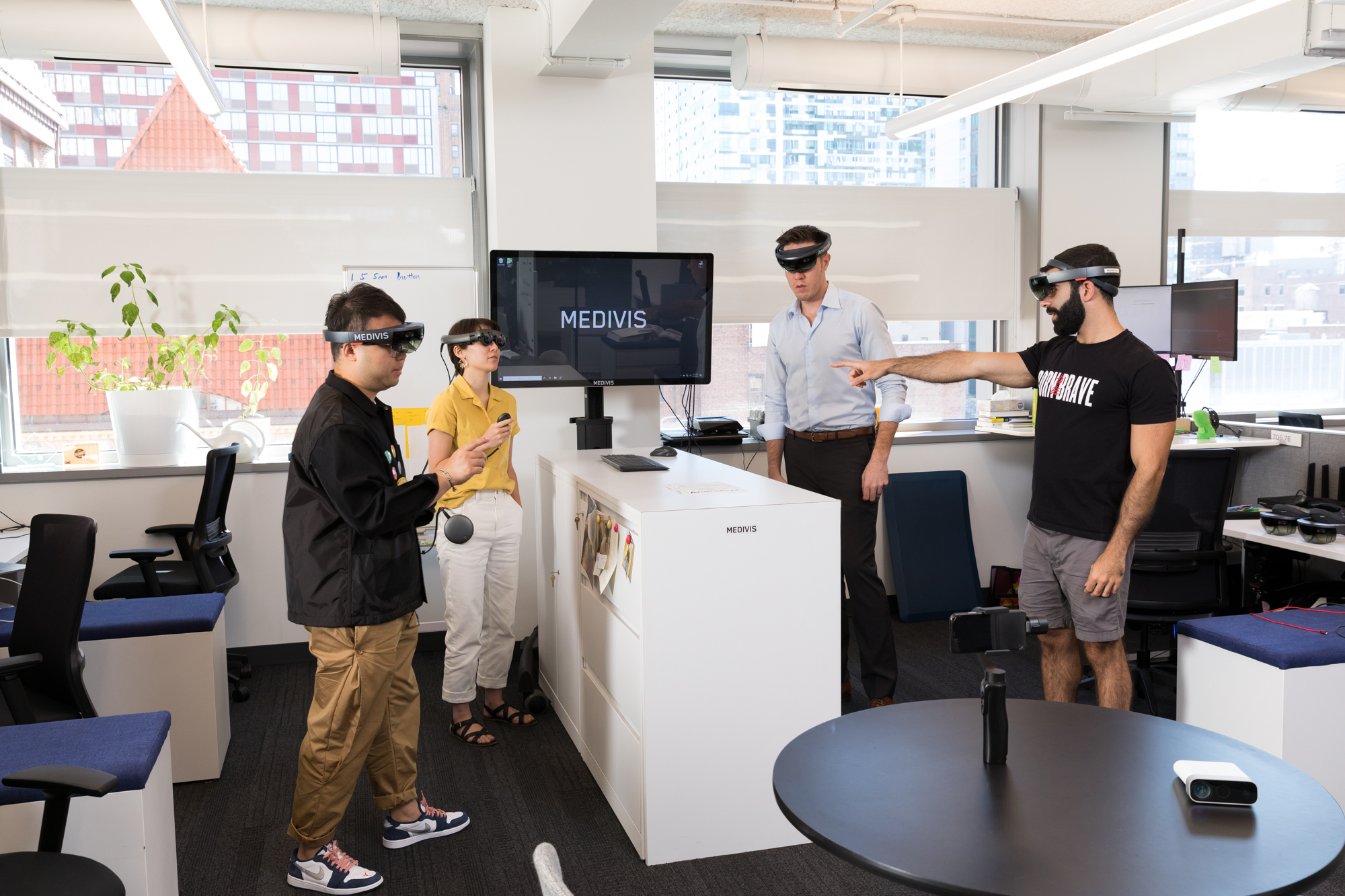 Four people wearing augmented-reality headsets during a Medivis office demonstration