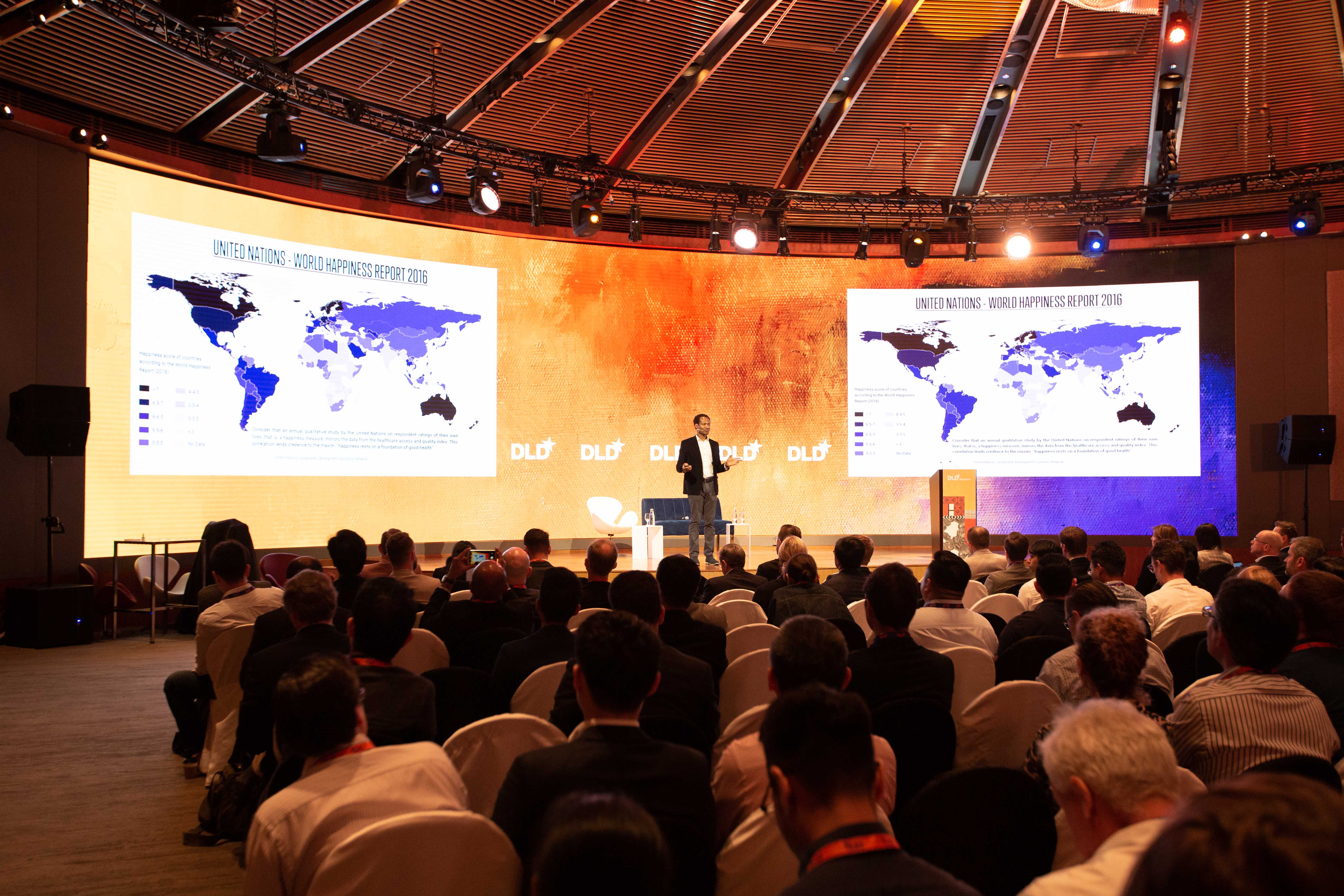 Osh Agabi speaking onstage to a seated audience at DLD Singapore