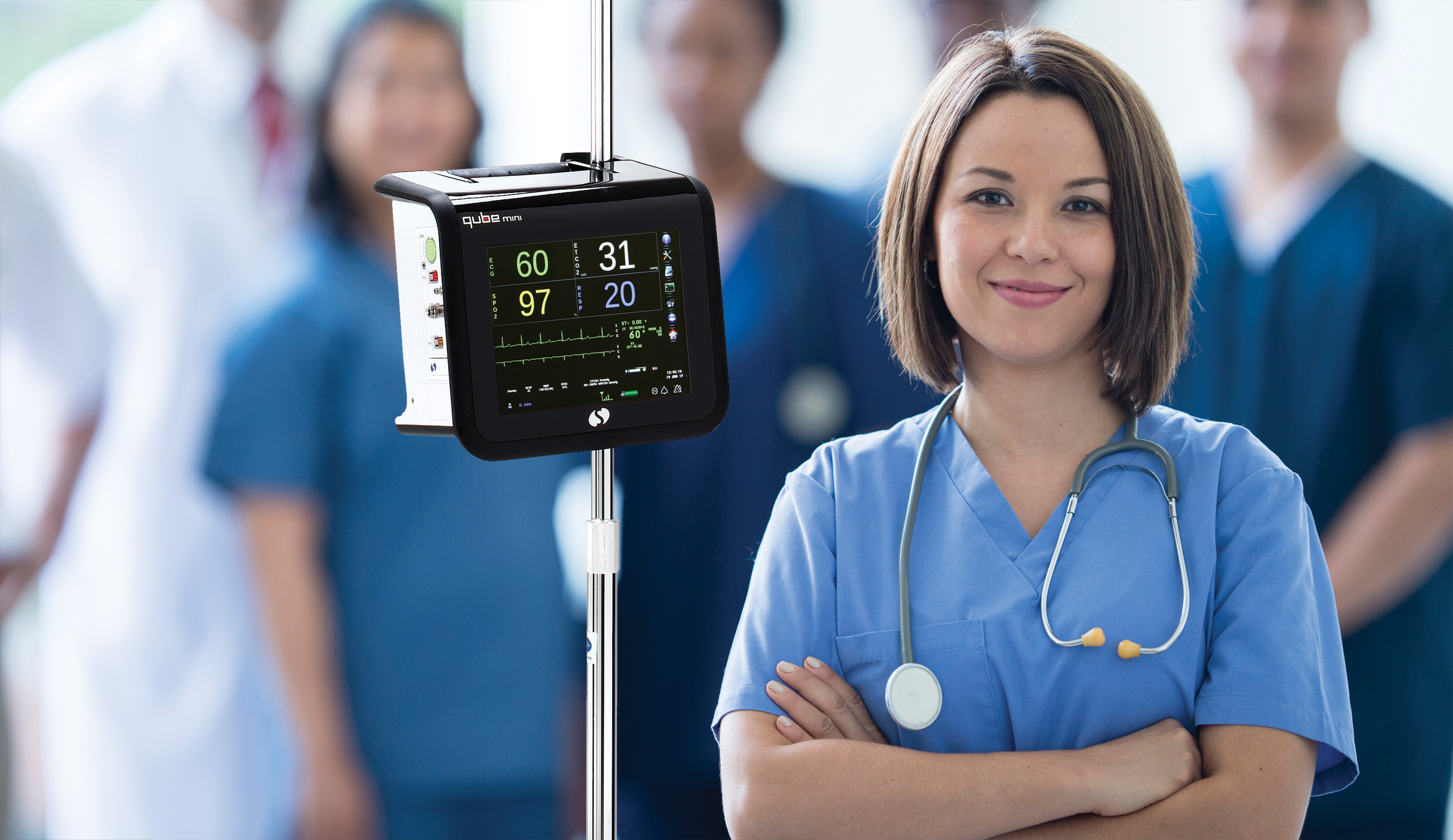 Nurse beside Spacelabs qube patient-monitoring equipment