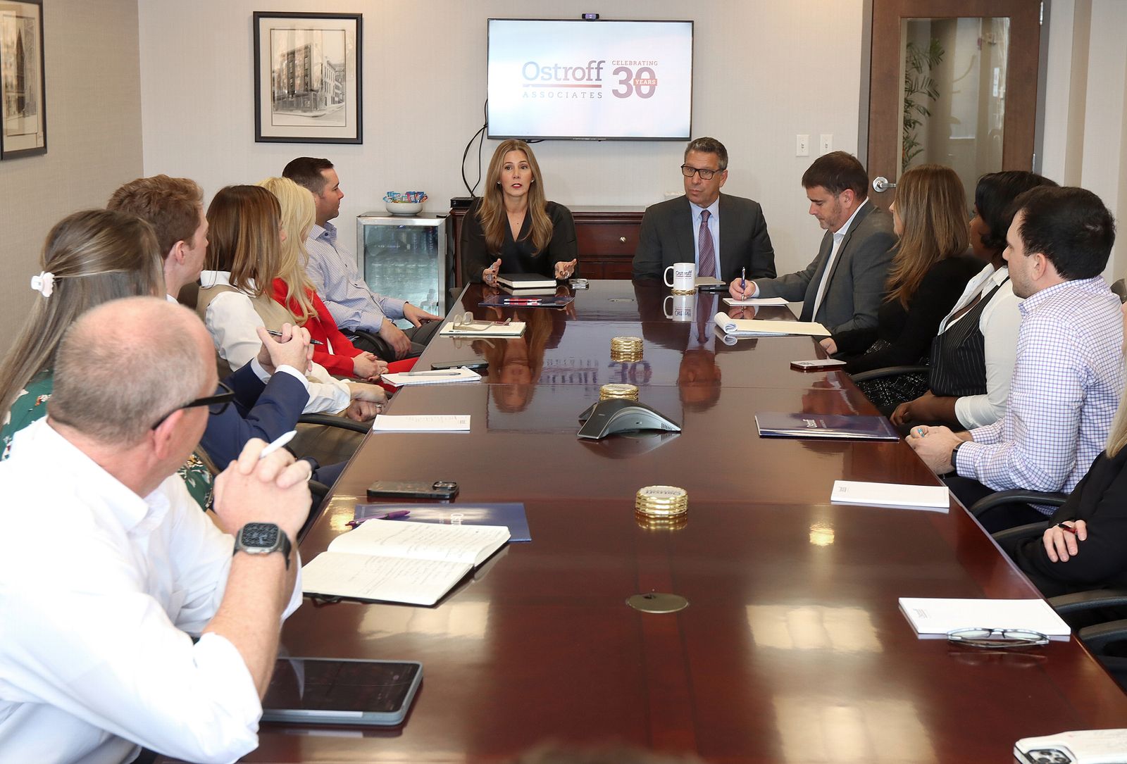 Ostroff Associates staff gathered around a conference table in the Albany office