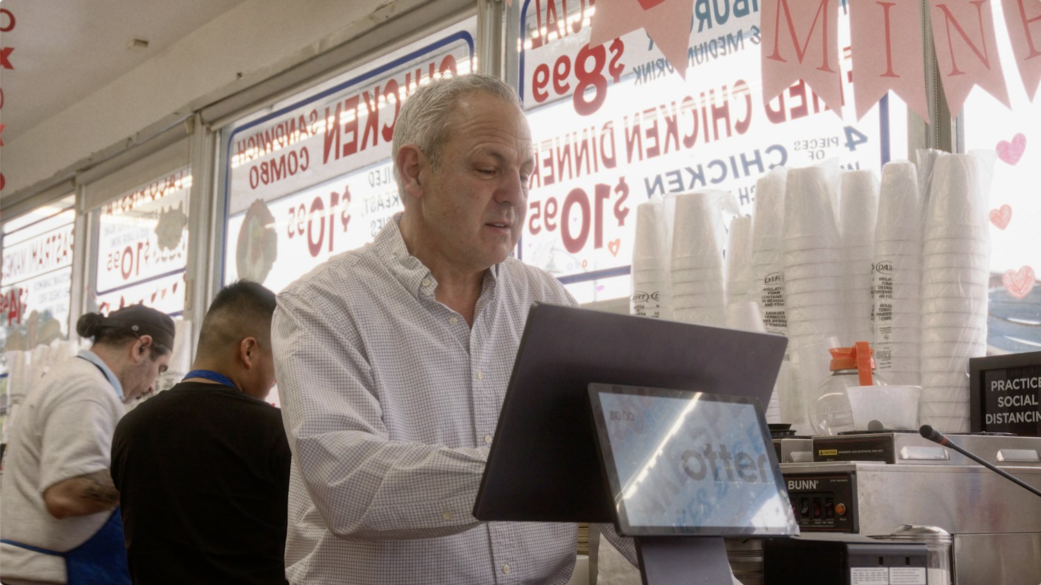 Jim’s Burgers owner at the counter with an Otter point-of-sale terminal