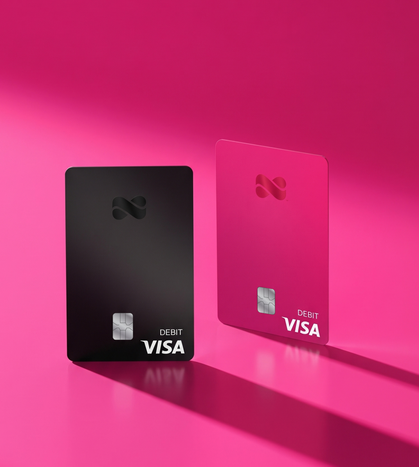 Black and pink Netspend Visa debit cards against a pink background