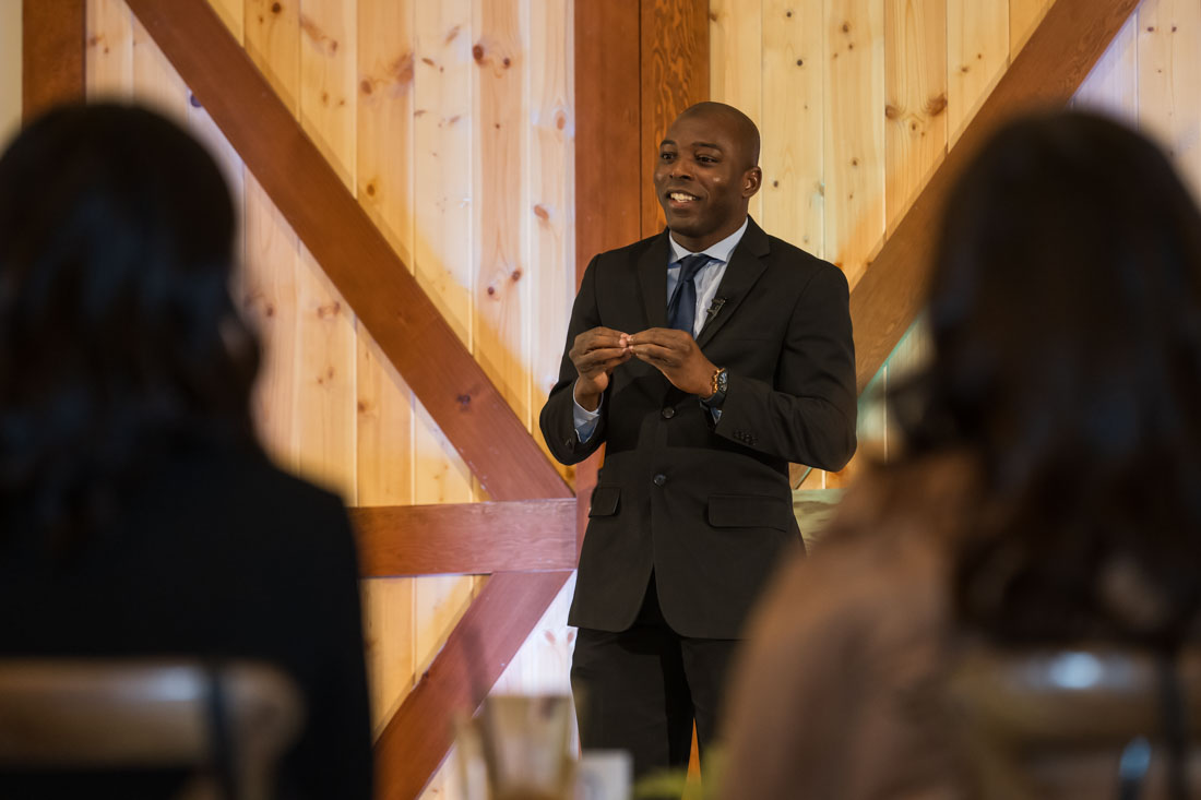 Ousmane Kabré speaking to an audience in a wood-paneled venue