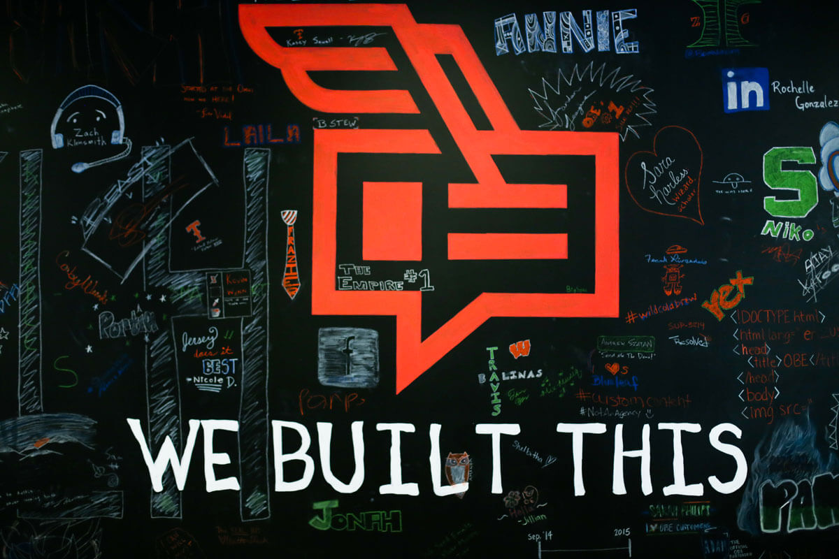 OutboundEngine chalkboard wall covered with employee drawings and the words We Built This