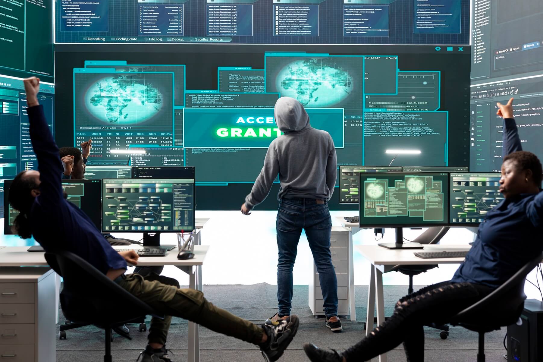 Illustrative cybersecurity scene with people facing large computer displays