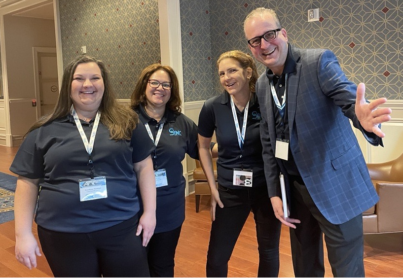 Outcomes team members gathered together at a company event