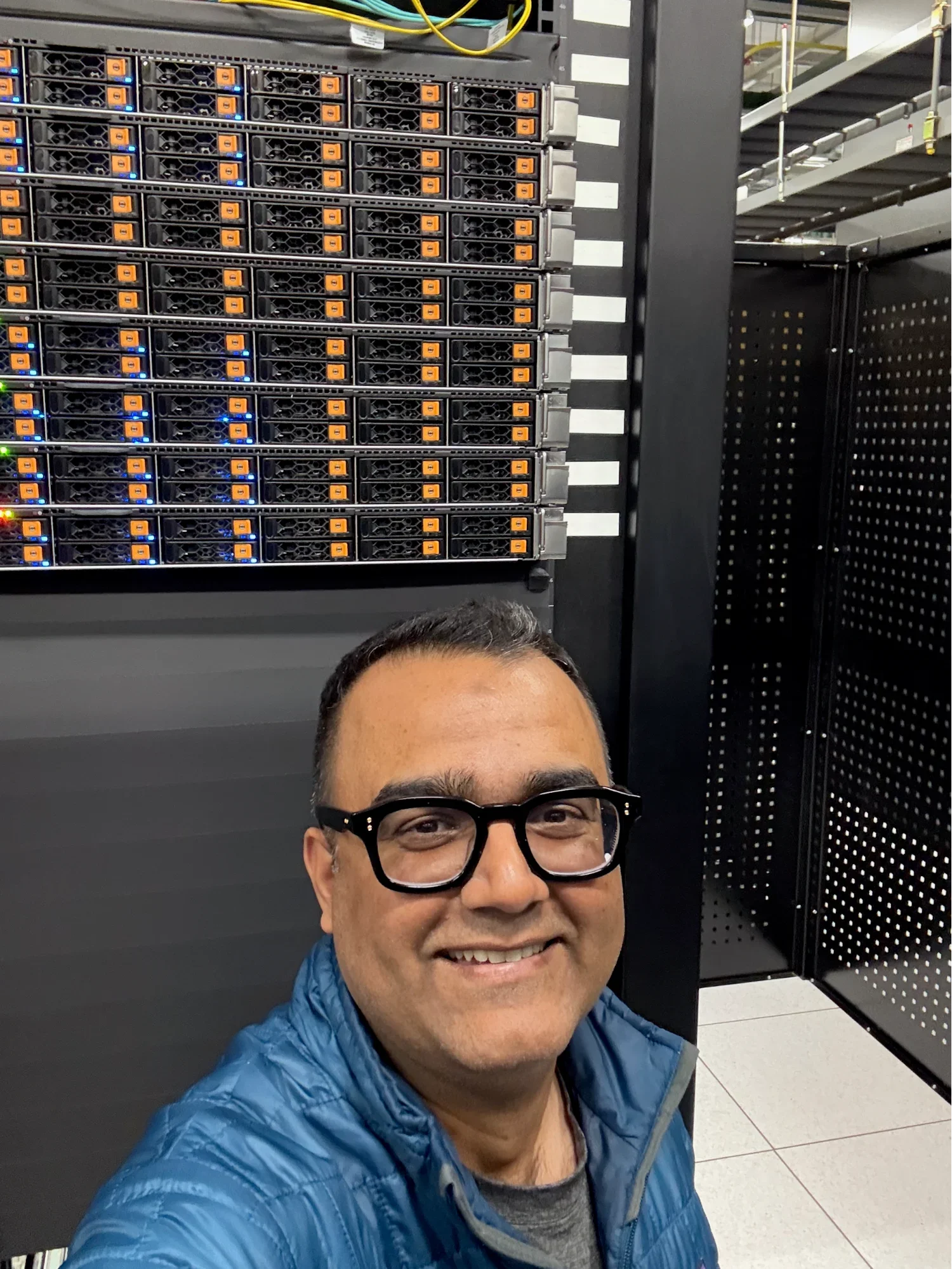 Ovais Tariq taking a selfie beside Tigris server hardware in a data center