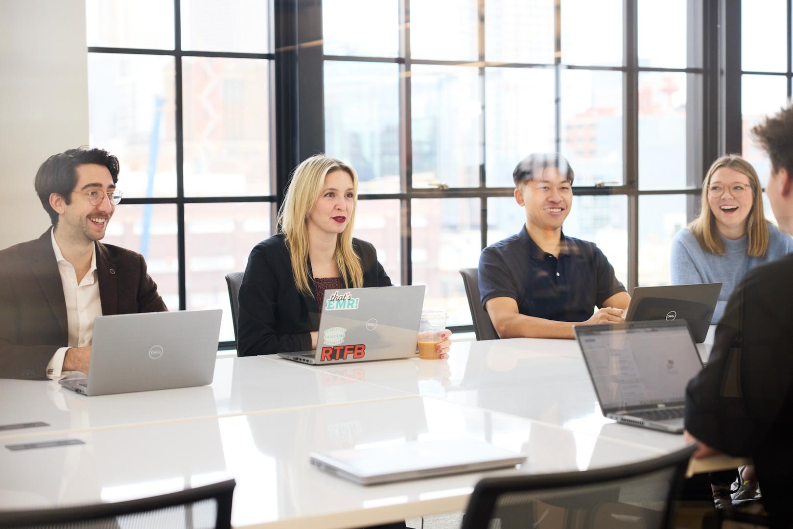 Ovative team members gathered around laptops at a meeting table