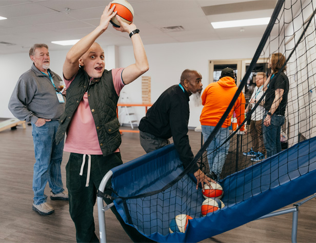 Overture employees playing Pop-A-Shot basketball in the office activity space