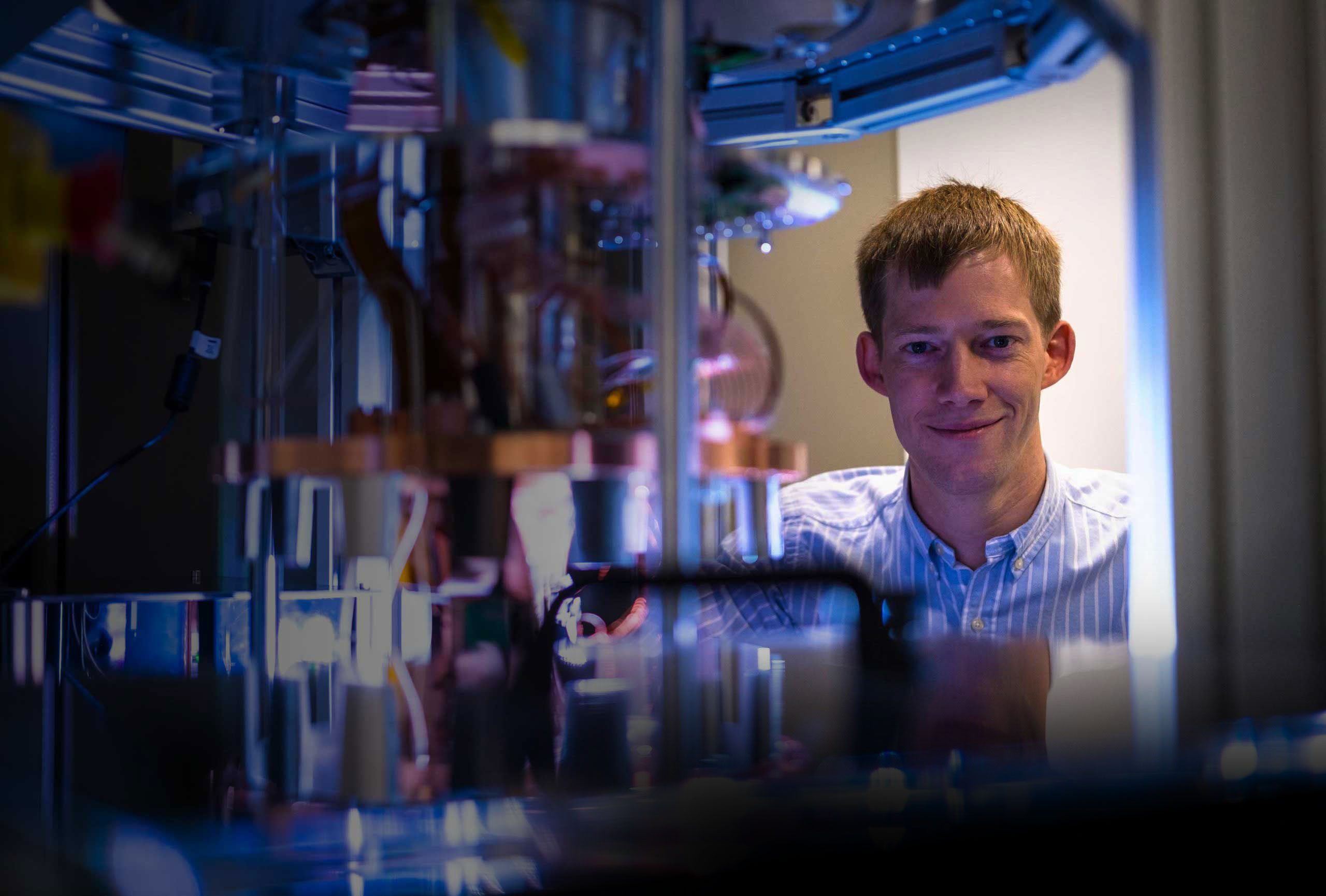 Oxford Ionics co-founder Chris Ballance beside laboratory equipment