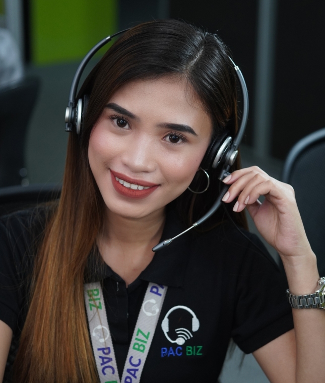 A Pac Biz staff member wearing a headset and company shirt