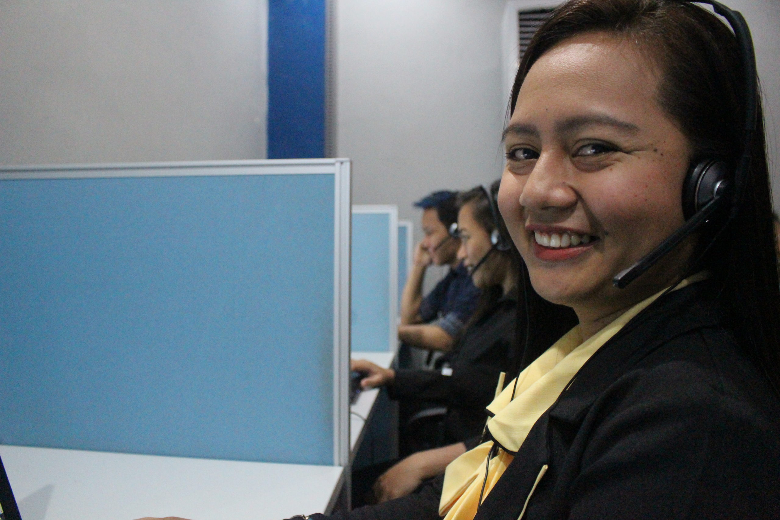 Pac Biz staff wearing headsets at workstations in a historical company photograph