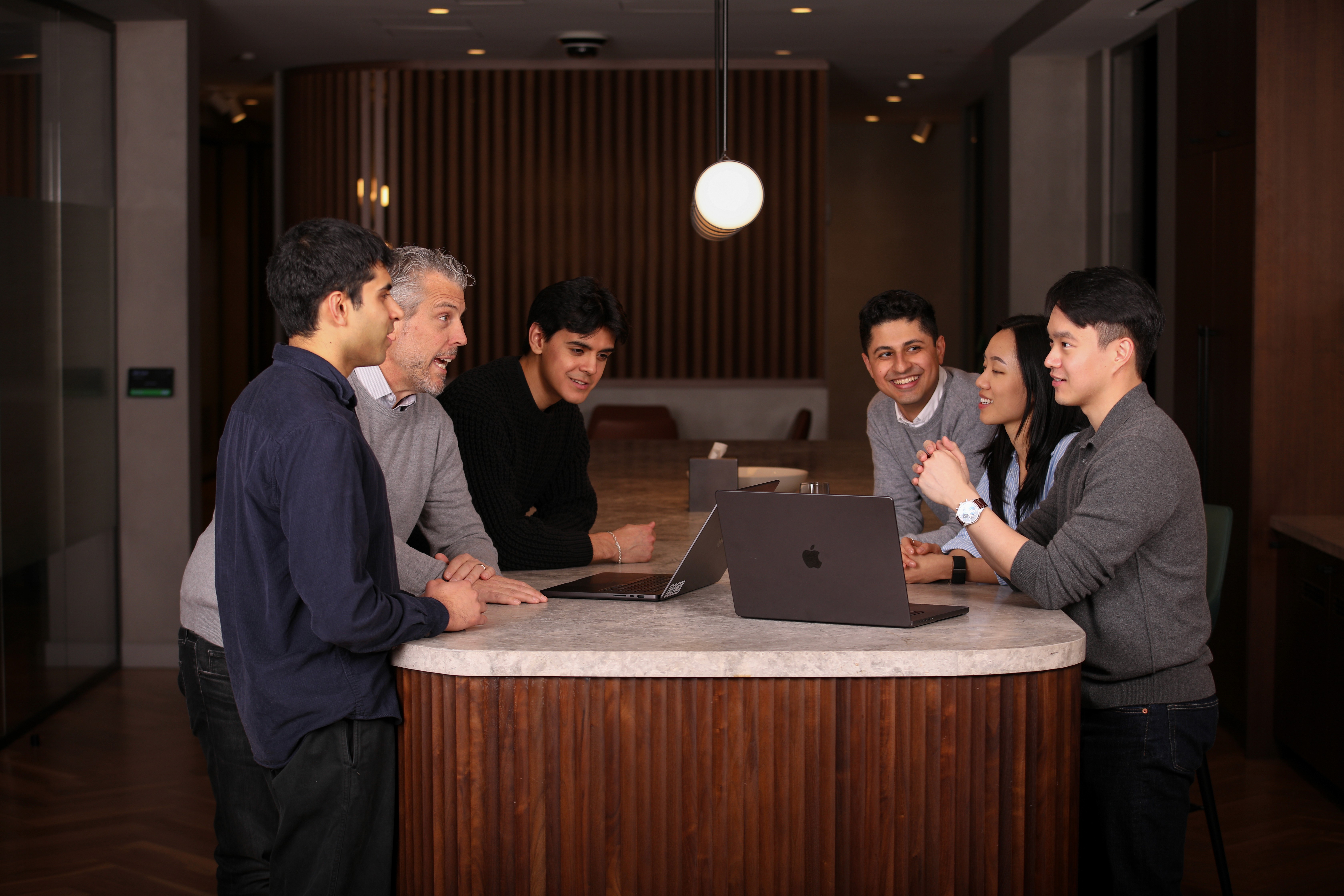 Pace colleagues gathered around laptops at a circular table