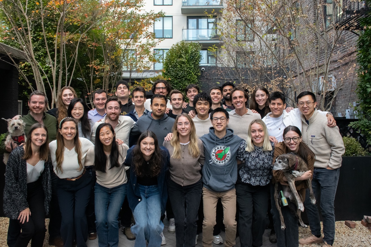 Paces team gathered outdoors with two dogs, in a photograph published in its January 2025 retrospective.