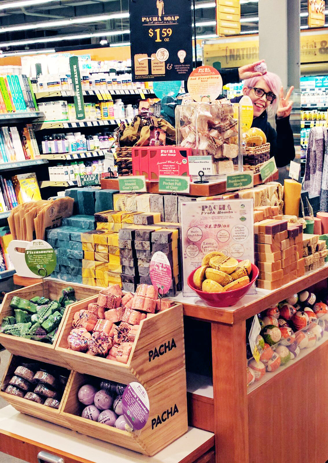 A colorful Pacha Soap retail display with stacked soap bars, bath bombs and wooden bins