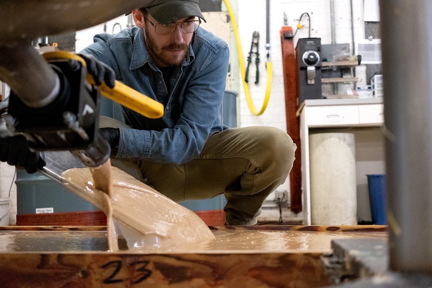 A Pacha soap maker pours a fresh batch into a wooden mold at the Hastings workshop