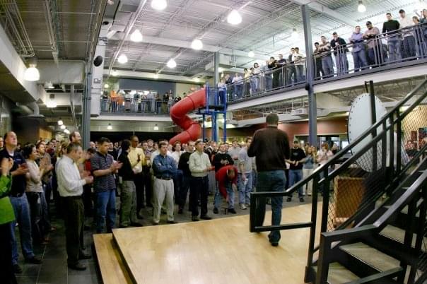 Hyland employees gathered on two levels for a company meeting beside an indoor slide