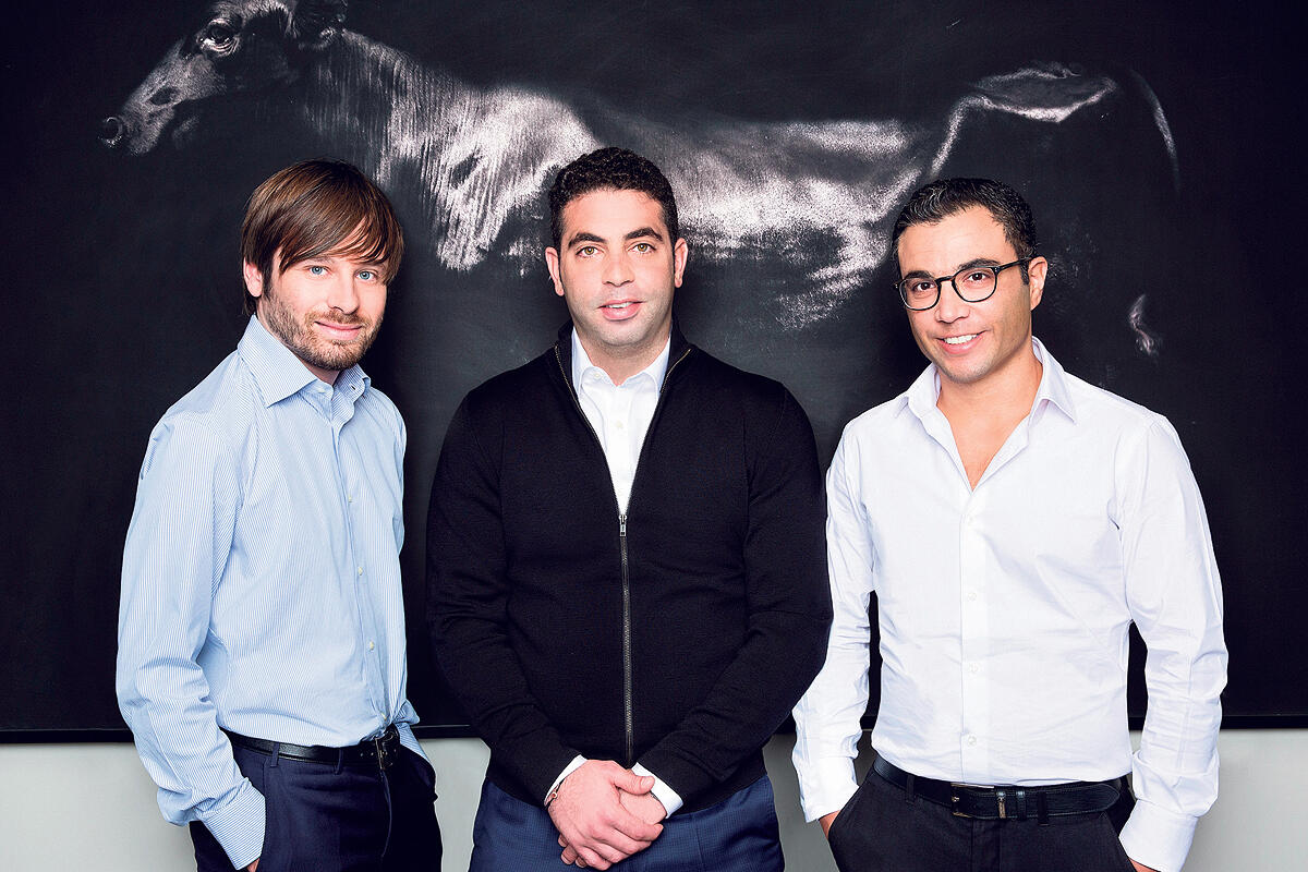 Pagaya’s three co-founders standing together in front of a dark wall with bull artwork