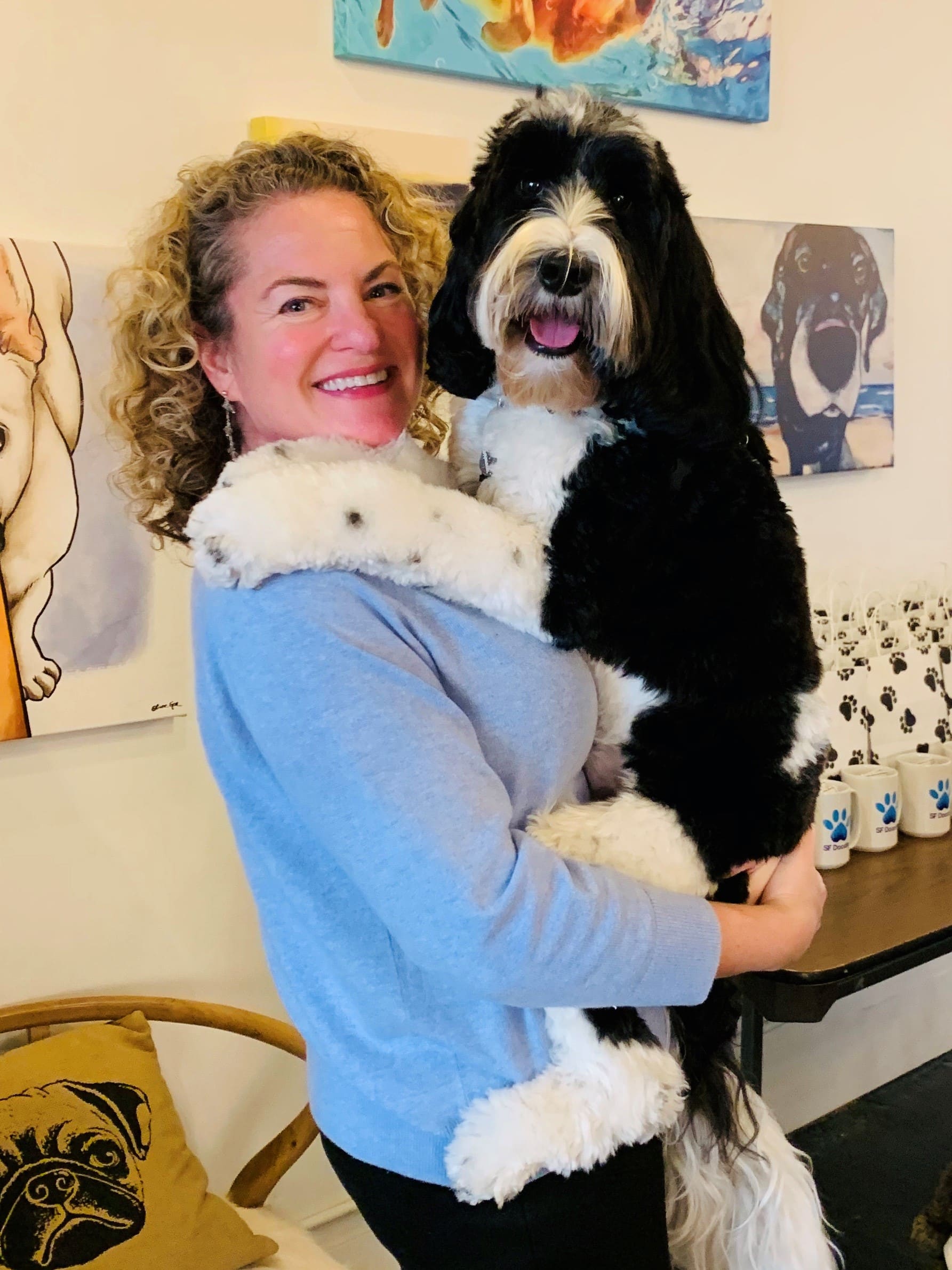 Paige Mantel holding her black-and-white Labradoodle, Samson