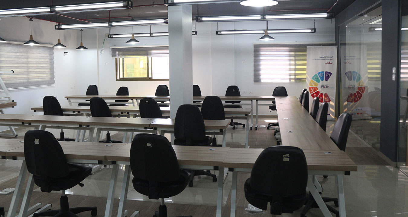 Rows of desks and chairs in a PICTI workspace, photographed for its website in 2022