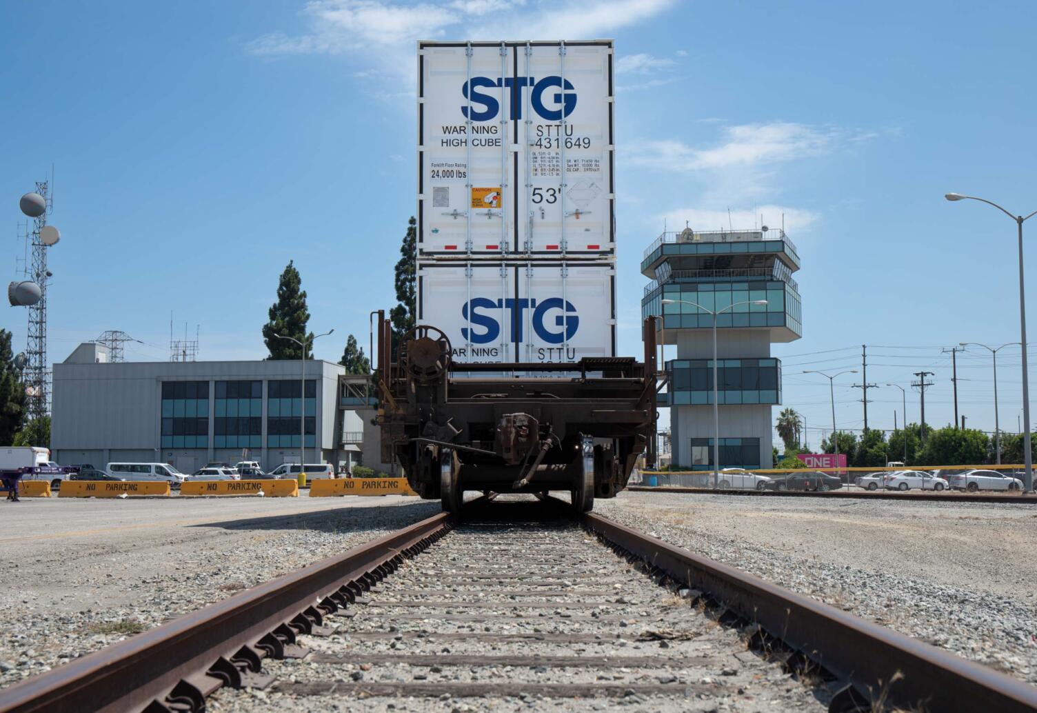 Two stacked STG intermodal containers on a railcar