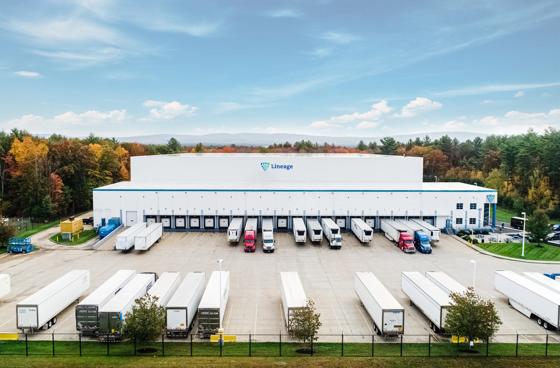 Aerial view of a Lineage temperature-controlled warehouse with refrigerated trailers at its loading docks