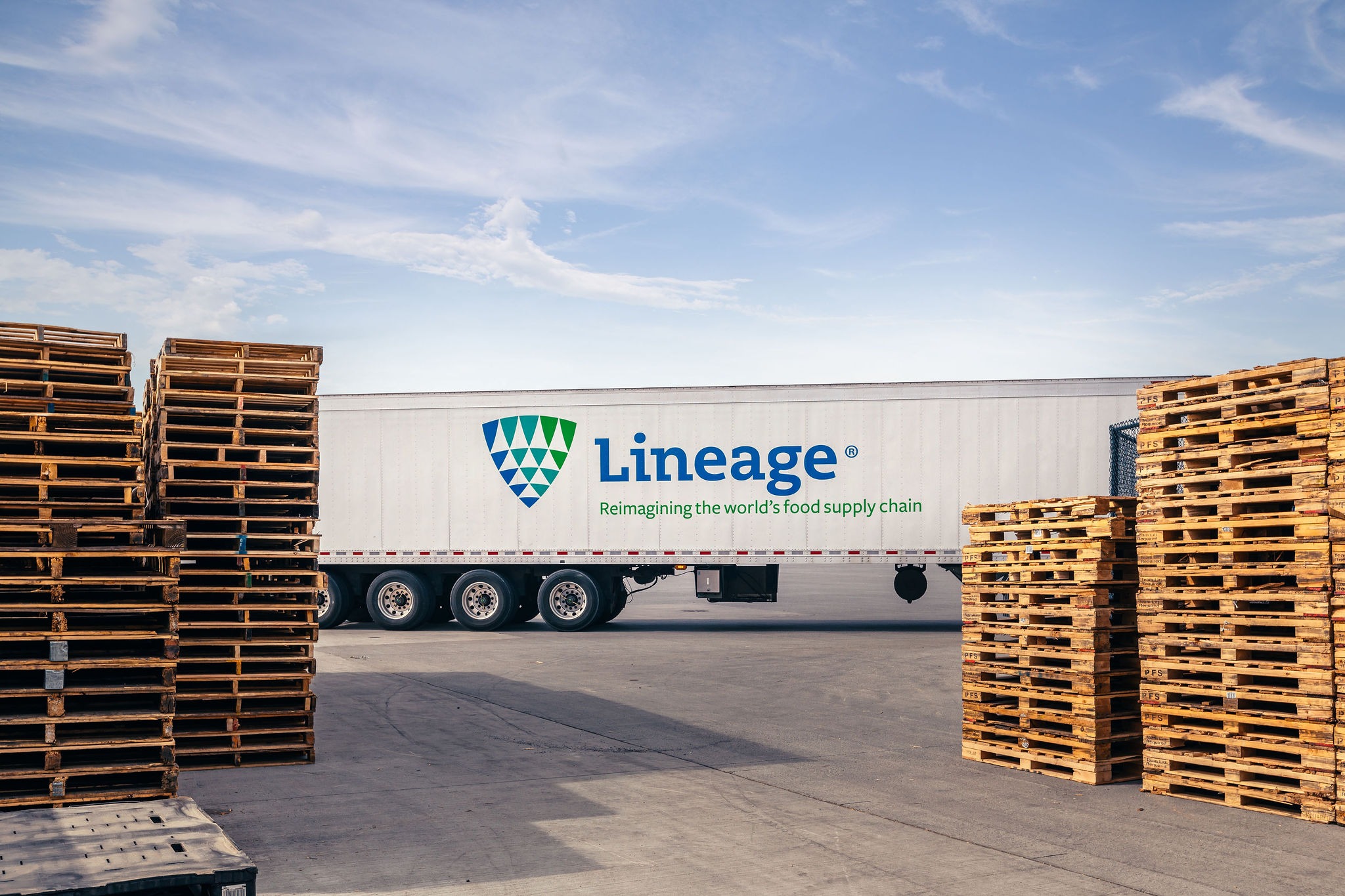 Lineage trailer framed by stacks of wooden pallets