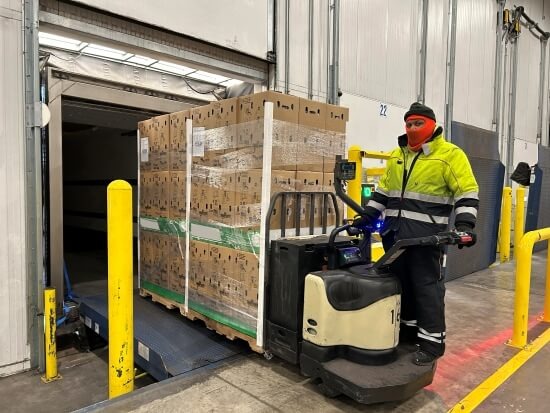 Lineage team member moving a loaded pallet jack at a receiving dock