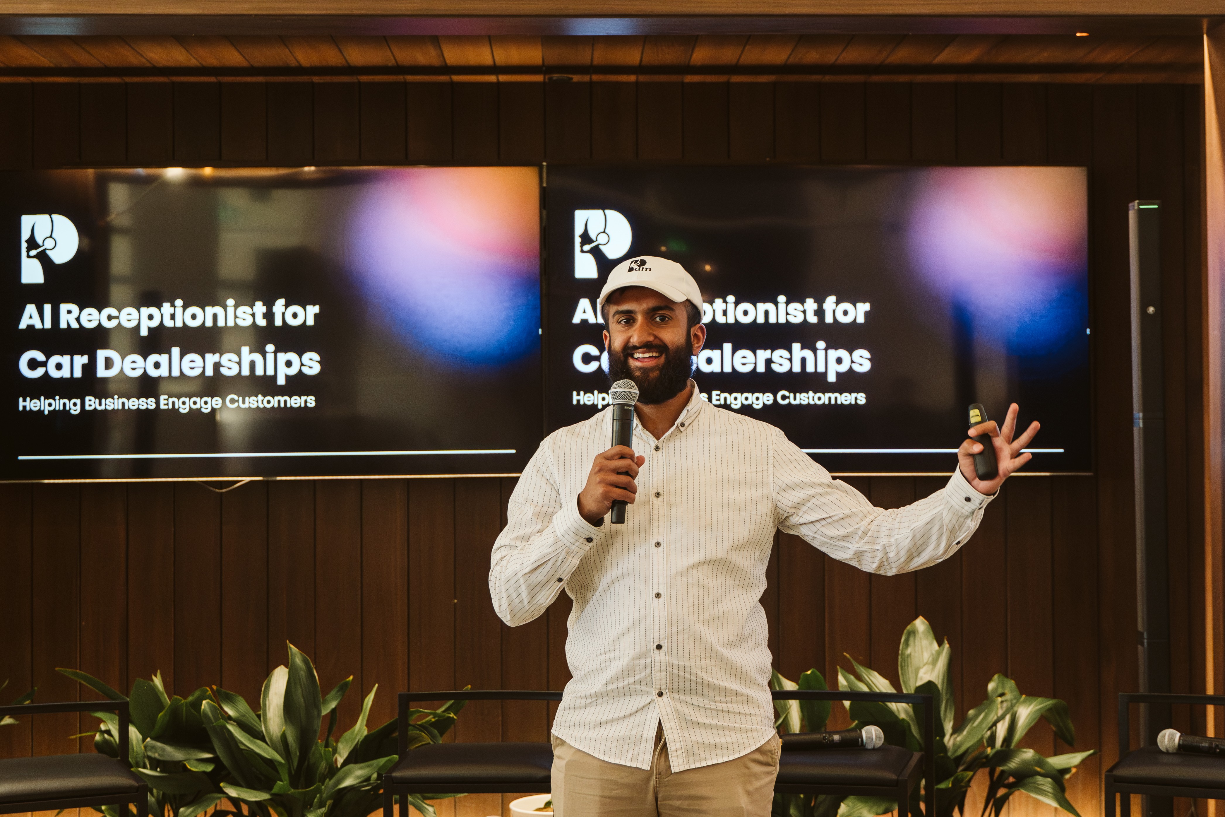 A speaker presents Pam’s AI receptionist for car dealerships at a company event