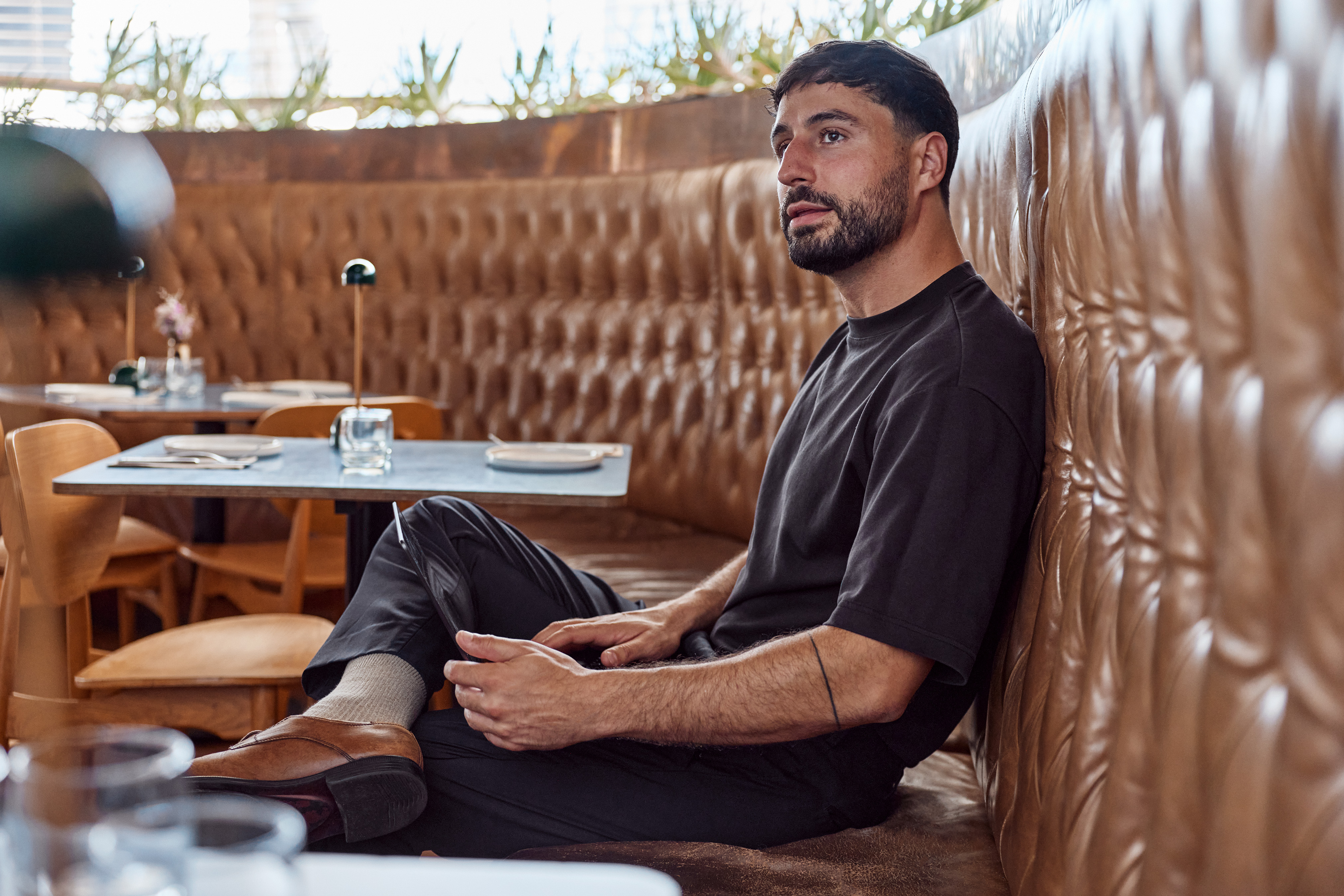 Pan Koutlakis seated in a leather restaurant booth at Rocker in North Bondi