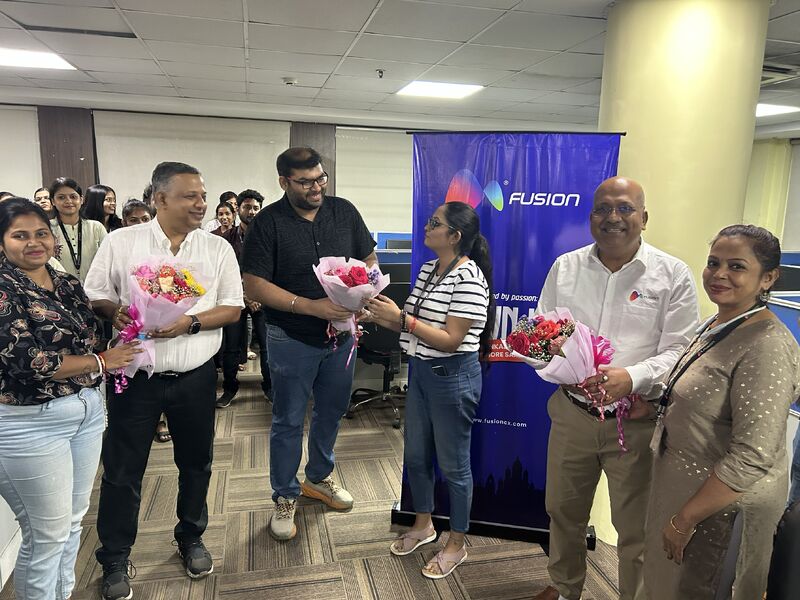 Pankaj Dhanuka, second from right, holding a bouquet among colleagues at Fusion CX’s Kolkata town hall.