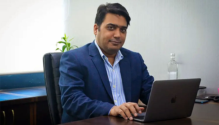Pankaj Tripathi seated at his desk with a laptop