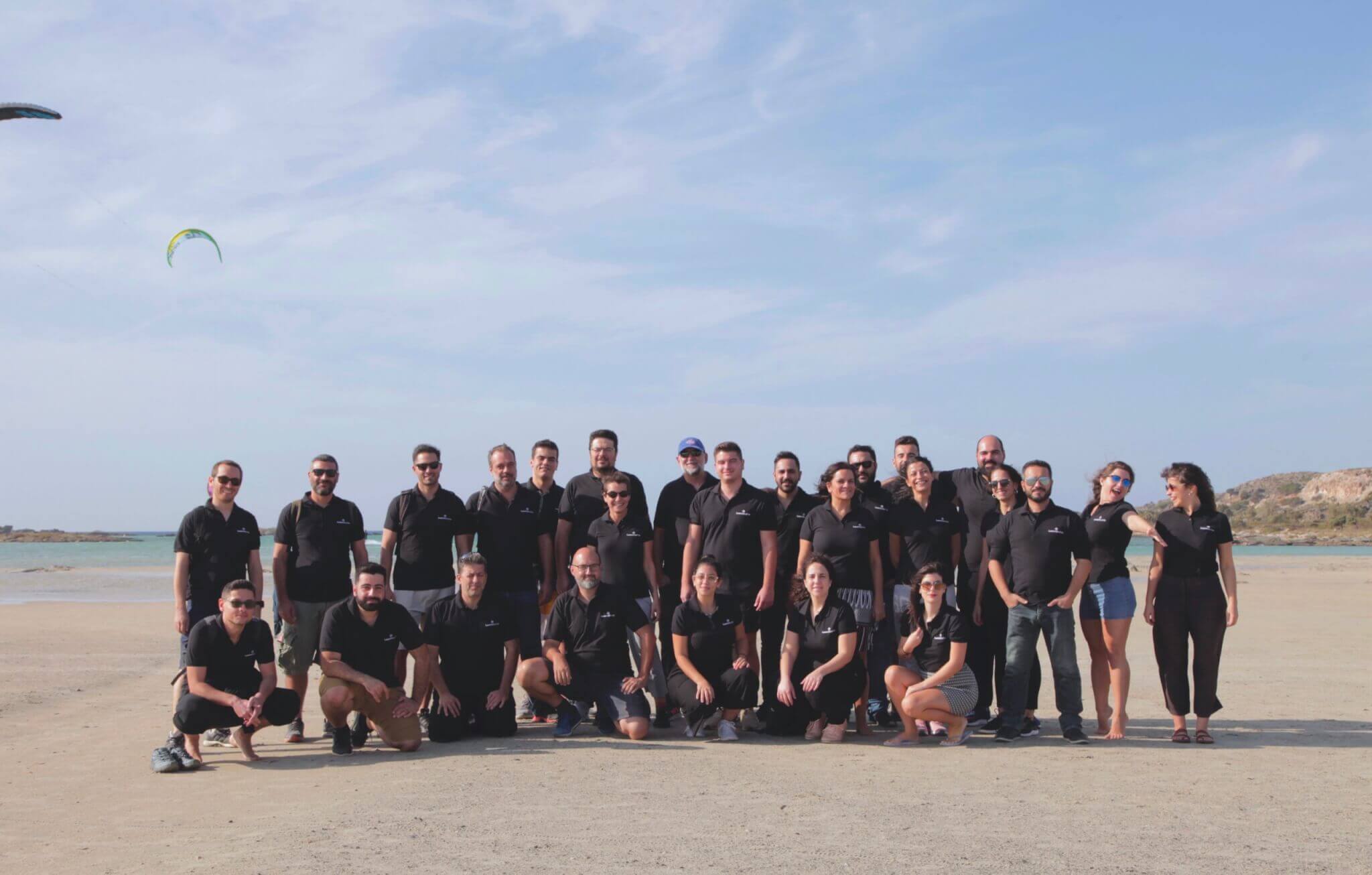 The LearnWorlds team gathered on a beach in a photograph accompanying the company's 2021 funding announcement