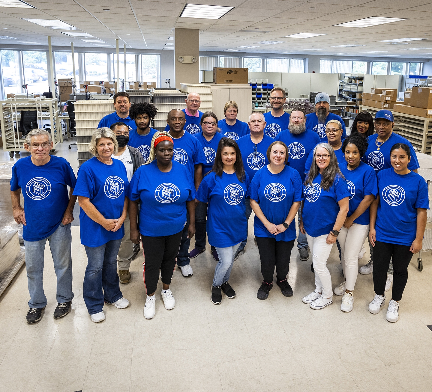PAR Excellence manufacturing team gathered among equipment and supply bins