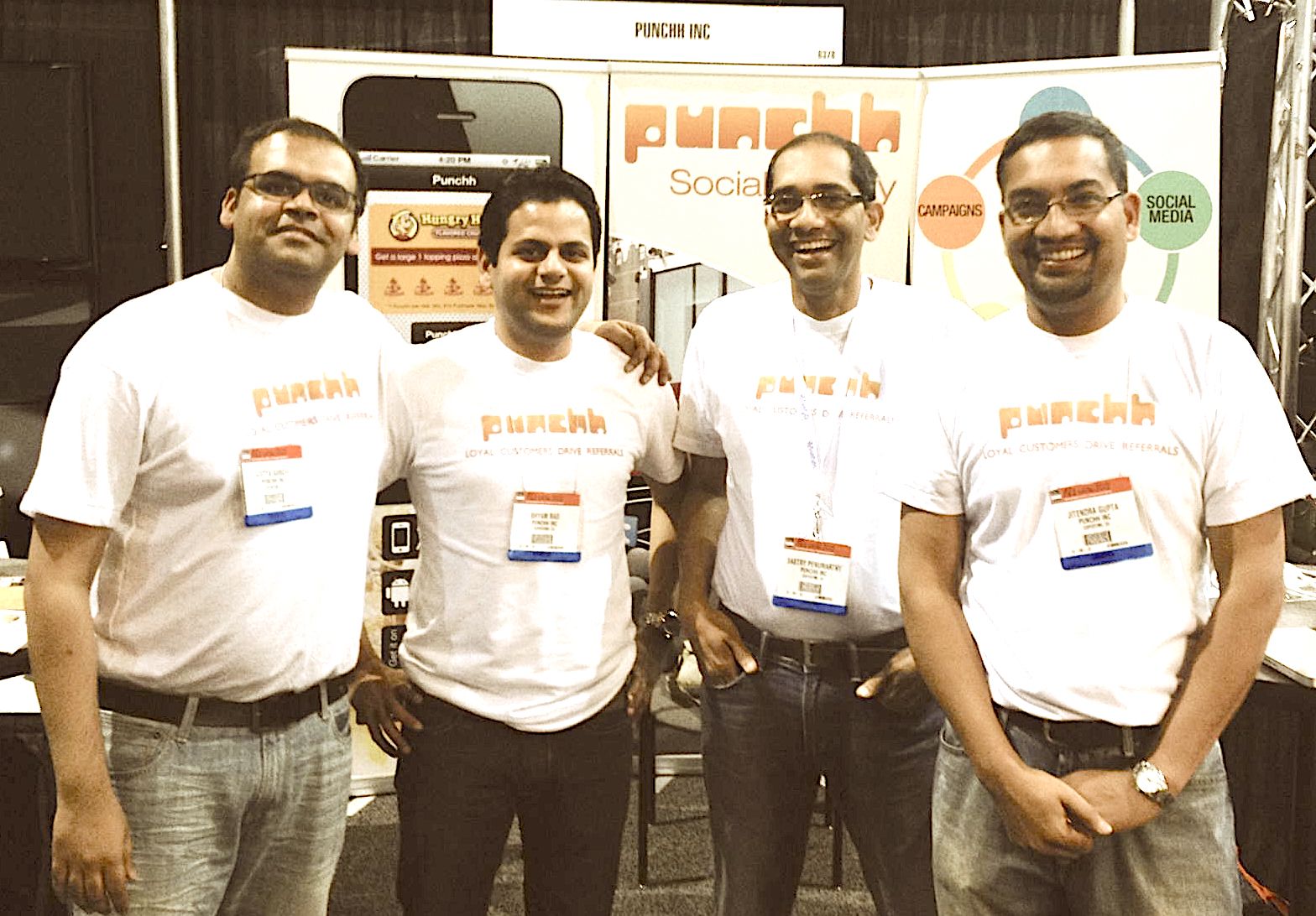 Punchh’s early founding team wearing matching company shirts at a trade-show booth