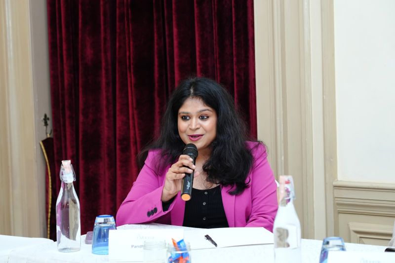 Paridhi Gupta speaking into a microphone during a marketing roundtable in Bengaluru