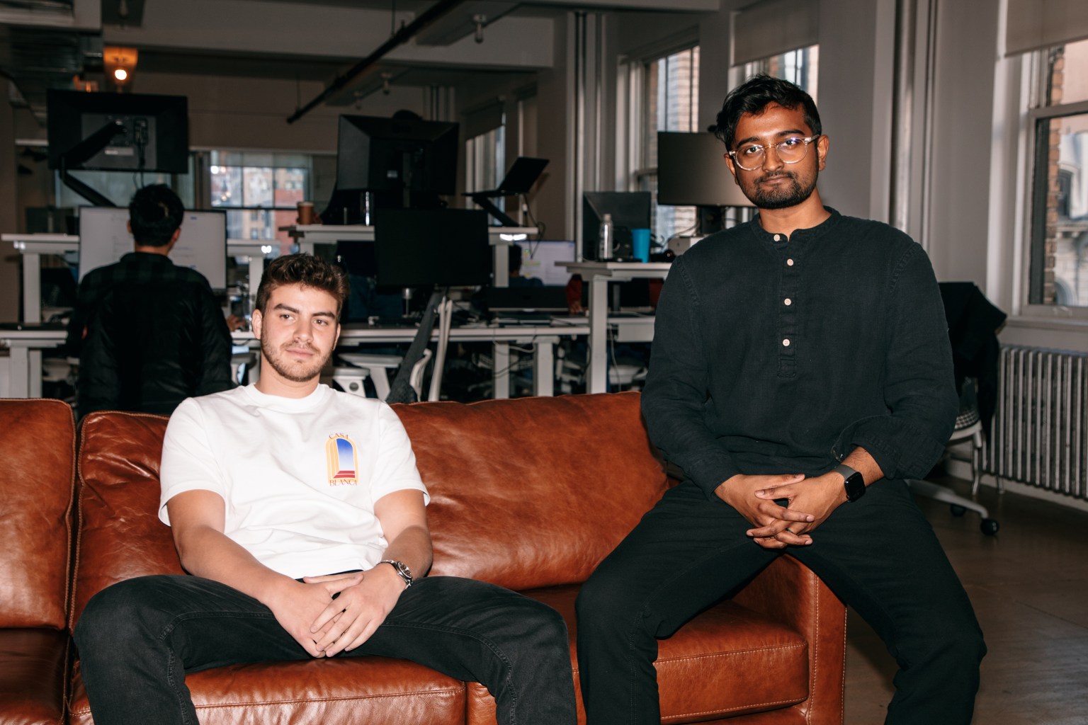 Parker co-founders sitting on a leather sofa in an office