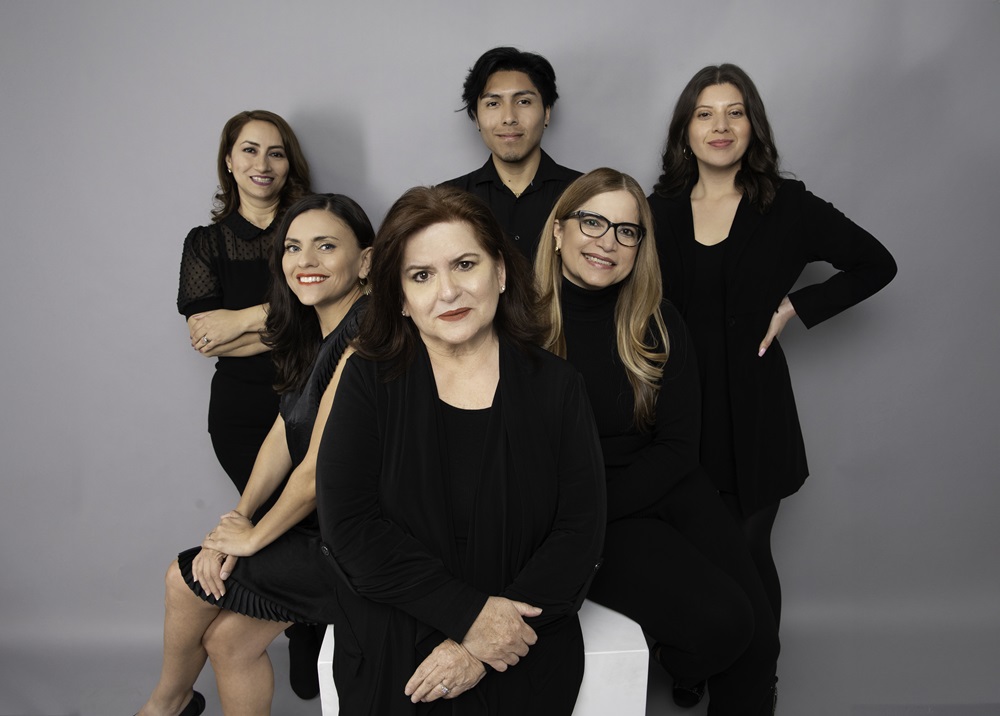 Patricia Pérez seated at the front of VPE Communications’ six-person 2024 staff photograph