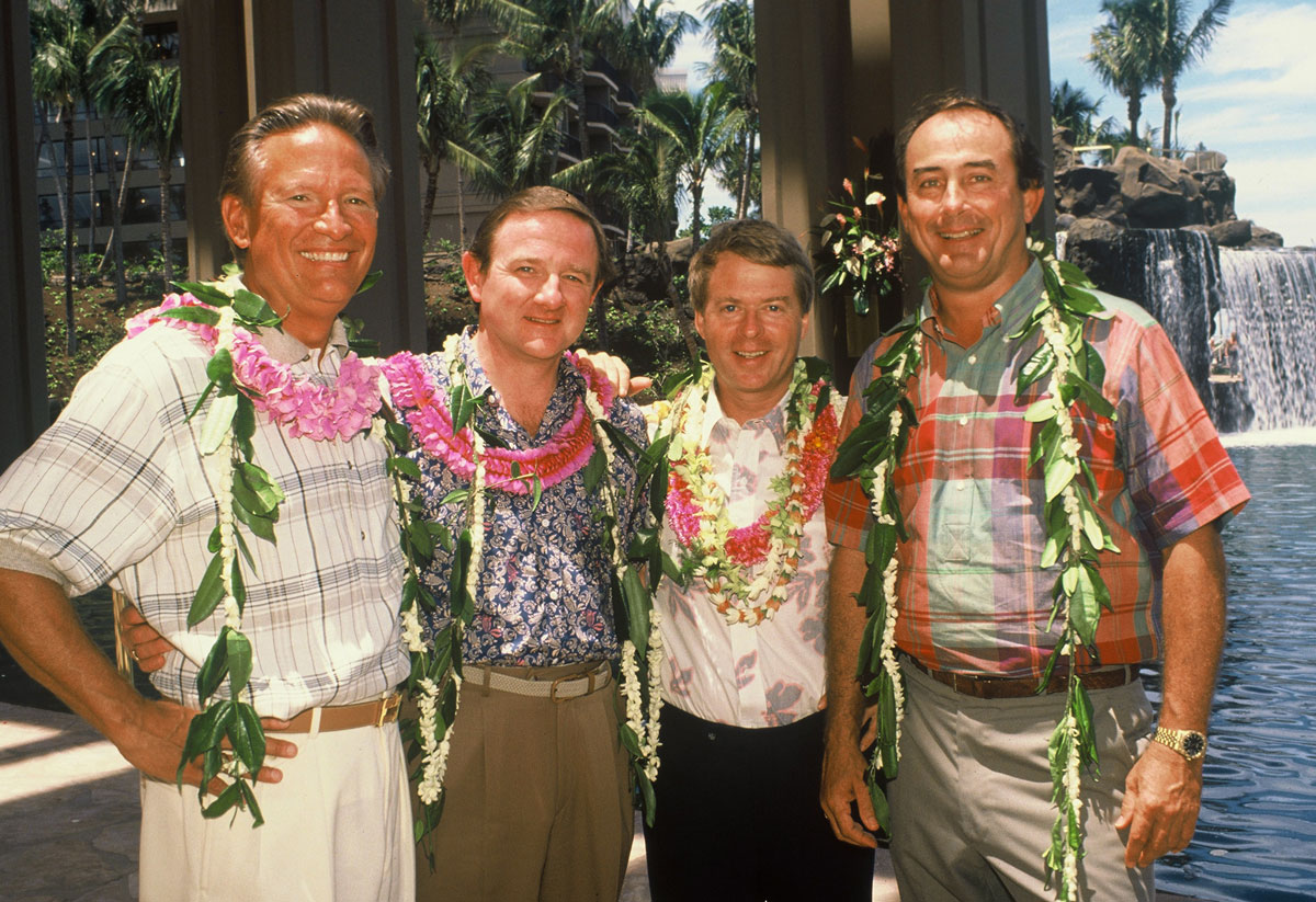 Four executives wearing flower leis at the Hyatt Regency Waikoloa opening in 1988; Patrick Cowell is third from left.